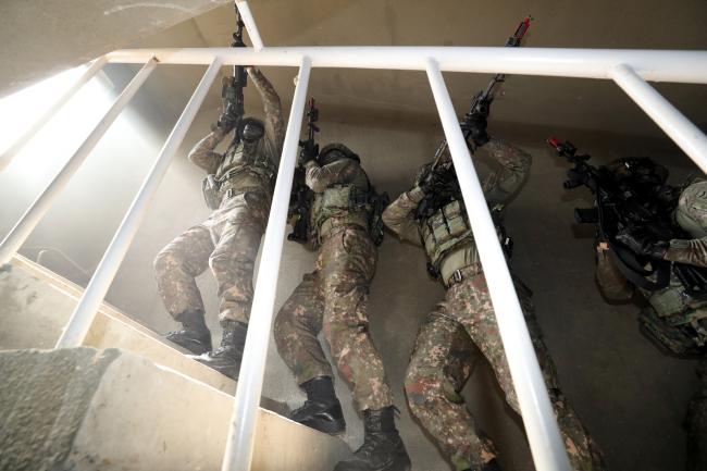 지난 16일 육군과학화전투훈련단에서 열린 전투실험에서 워리어 플랫폼을 장착한 전투원들이 적을 소탕하기 위해 계단을 오르는 모습.
