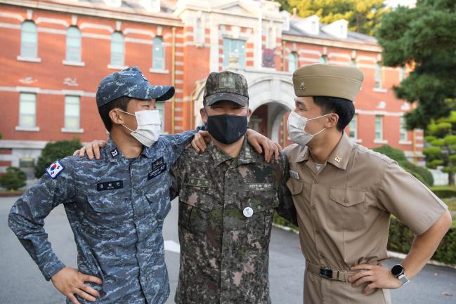 김동환(가운데) 중령이 해군진해기지사령부 본청 건물 앞에서 두 아들과 기념사진을 찍고 있다.  사진 제공=전준혁 하사