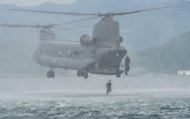 해군특수전전단 해난구조전대(SSU) 대원들이 13일 공군6탐색구조비행전대와 합동 항공구조훈련을 진행해 HH-47 헬기에서 바다로 뛰어들고 있다.  부대 제공