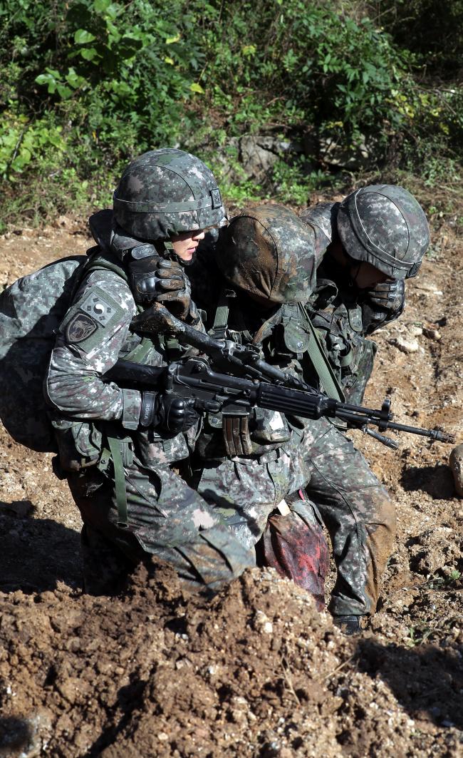 전문교관팀이 교전 지역에서 부상을 입은 전우를 안전한 곳으로 옮기고 있다.