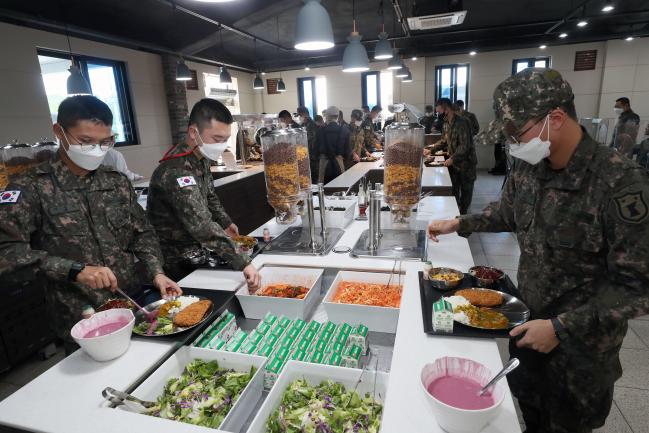 육군32보병사단 장병들이 13일 ‘더 좋은 병영식당’에서 점심식사 전 원하는 음식을 고르고 있다. 이날 메뉴로는 장병 선호도를 반영한 돈가스, 쫄면, 카레, 소시지 등이 제공됐다.  한재호 기자