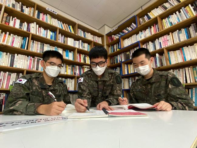 육군22보병사단 백호돌격대대 김동영(가운데) 상병이 전우들의 공부를 돕고 있다.  사진 제공=문초록 중위