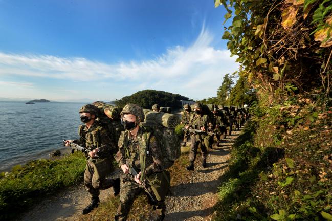 25일 해군사관학교 1·2·3학년 사관생도들이 25㎏ 완전 무장으로 진해군항 내 영내코스를 행군하고 있다.  부대 제공