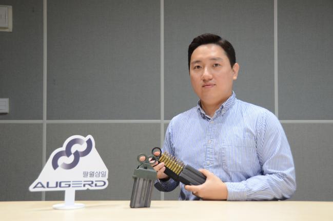 팔월삼일 맹동주 대표가 수동급속삽탄기를 들고 포즈를 취하고 있다.