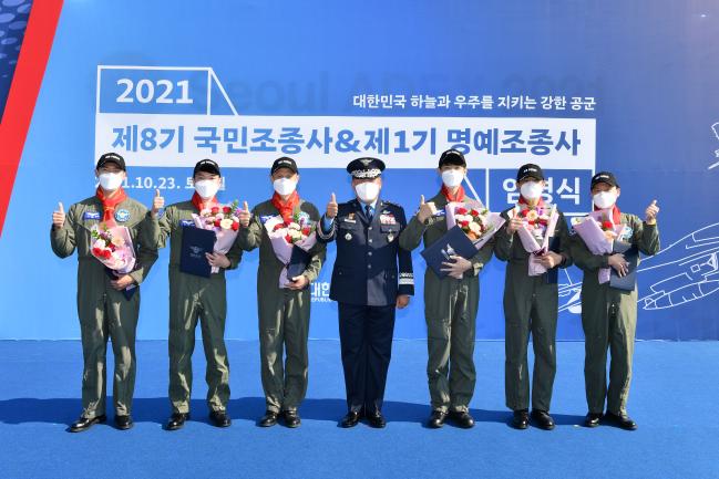 제8기 국민조종사들과 제1기 명예조종사들이 지난 23일 박인호(가운데) 공군참모총장으로부터 조종사 임명장을받은 뒤 기념사진을 찍고 있다.  공군 제공