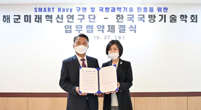 박동선(왼쪽) 해군 미래혁신연구단장과 박영욱 한국국방기술학회장이  27일 대전시 유성구 계룡스파텔에서 열린 공동발전 및 교류협력 증진을 위한 업무협약 체결식에서 협약서를 들어보이고 있다. 해군 제공