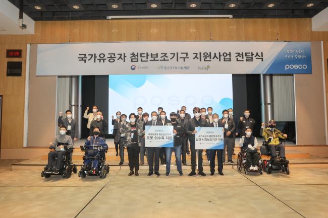 황기철(앞줄 왼쪽 넷째) 국가보훈처장이 1일 상이 국가유공자 첨단 보철구 전달식에서 양원준(앞줄 오른쪽 셋째) 포스코 경영지원본부장, 보철구 지원 선정자, 관계자 등과 함께 기념촬영을 하고 있다.  보훈처 제공