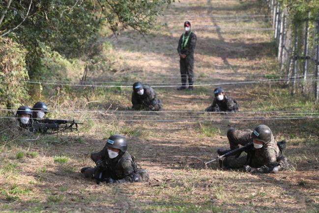 육군훈련소 훈련병이 응용포복을 하며 장애물 지역을 극복하고 있다.