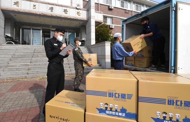 해군교육사령부 특기별 교육을 마치고 첫 부임지로 떠나는 강현(맨 오른쪽) 일병이 생활관 앞에서 바다로 서비스를 이용해 보급품을 근무 부대로 보내고 있다.  사진 제공=강승연 하사