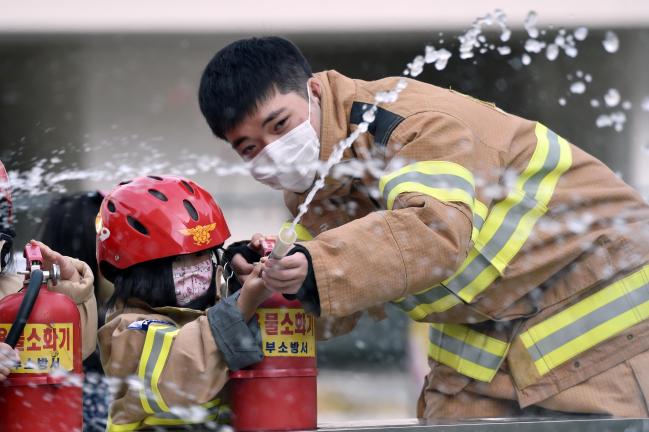 공군17전투비행단 소방구조중대 장병이 관사에 거주하는 어린이들에게 소화기 사용법을 교육하고 있다.  사진 제공=한찬혁 병장