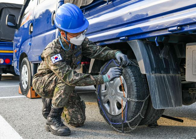공군16전투비행단 체인 장착 경연대회에 참가한 장병이 차량에 체인을 장착하고 있다.  사진 제공=이승헌 병장
