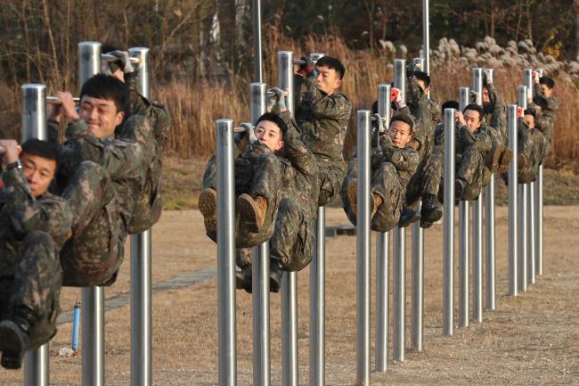 철봉 매달려 웅크리기(레그턱)를 하고 있는 교육생들. 