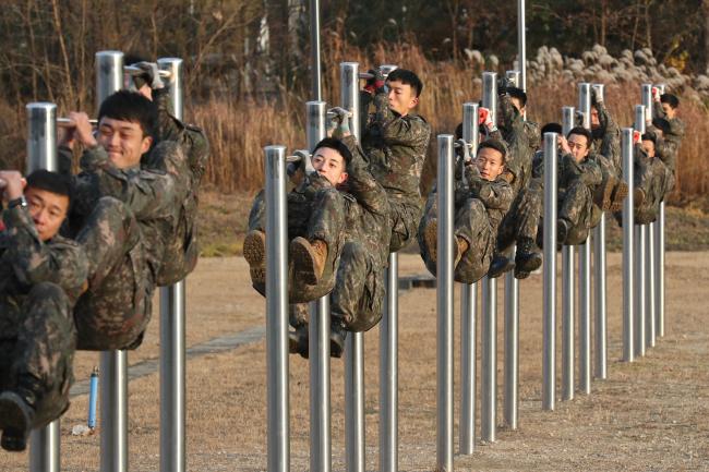 철봉 매달려 웅크리기(레그턱)를 하고 있는 교육생들. 