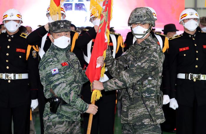 김태성(왼쪽) 해병대사령관이 1일 경북 포항시 해병대 항공단에서 열린 항공단 창설식 및 항공단장 취임식에서 초대 단장 지은구 대령에게 부대기를 수여하고 있다.
