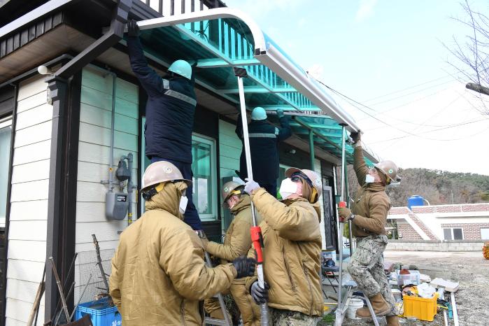 한미 해군 장병들이 인천 덕적도에 거주하는 베트남전쟁 참전용사 가정을 찾아 처마 보수 작업을 하고 있다.  부대 제공 