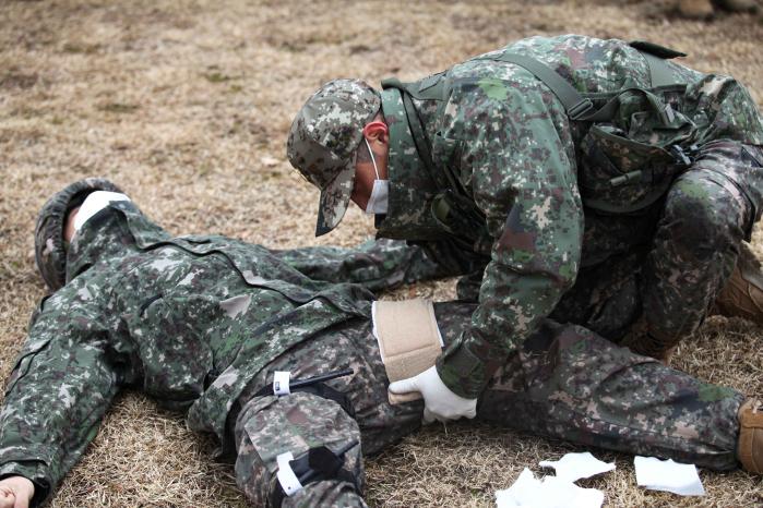 육군5보병사단에서 개최한 ‘전투부상자처치(TCCC)’ 시범식 교육에 참가한 전문교관이 전장에서 부상을 당한 전우를 구하기 위한 응급처치법 실습을 하고 있다.  사진 제공=박병준 상병