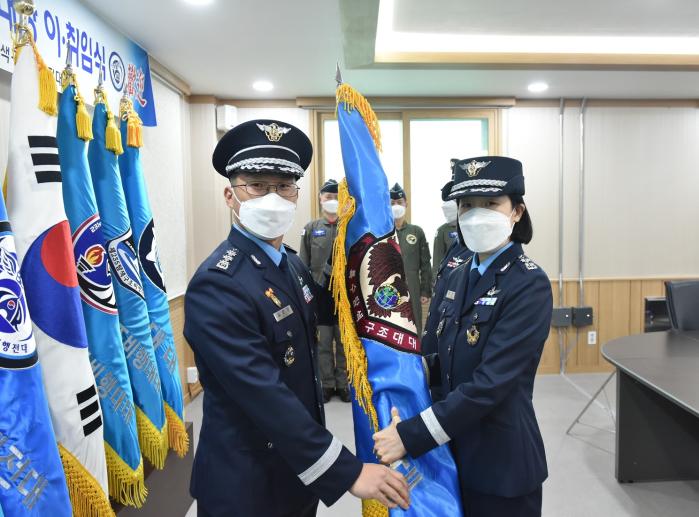 공군 최초로 여군 특수탐색구조대대장이 된 임은영 중령이 김보근(대령·왼쪽) 전대장으로부터 부대기를 받고 있다.  사진 제공=이신영 소위