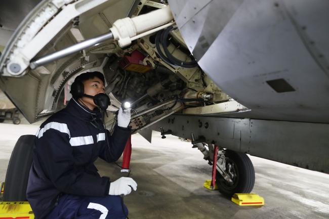 공군19전투비행단 정비사가 격납고에서 F-16 전투기 비행 전 점검을 하고 있다. 