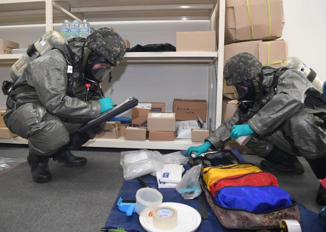 공군16전투비행단 화생방지원대 장병들이 12일 화생방 신속대응팀 훈련에서 생물학 작용제 의심물체로 판단되는 시료를 채취하고 있다.  사진 제공=신명재 하사