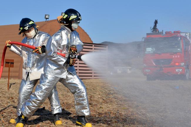 공군11전투비행단 소방구조 중대원들이 항공기 화재를 가정한 훈련에서 방수포로 화재를 진압하고 있다.   사진 제공=한윤창 하사