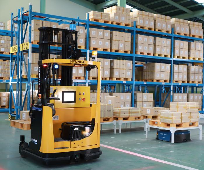 종합보급창 스마트 창고에서 자율이송로봇이 보급품을 무인 지게차로 옮기고 있다.