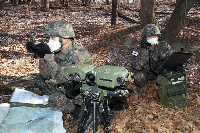 유영훈(왼쪽) 중위가 M2 나침반을 이용해 적의 위치를 확인하고 있다. 관측무전병 제갈원 상병은 유 중위가 산출한 제원을 무전기로 전달하고 있다.