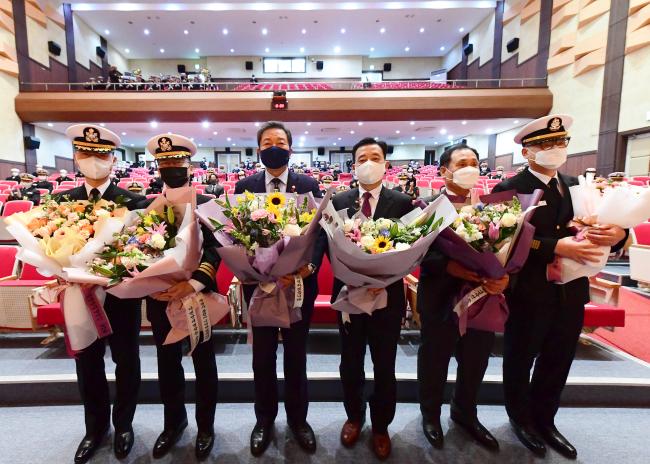 지난 21일 해군작전사령부 부산작전기지 대강당에서 열린 아덴만 여명작전 11주년 기념행사에서 황기철(왼쪽 셋째) 국가보훈처장을 비롯한 참석자들이 기념 촬영을 하고 있다.  부대 제공