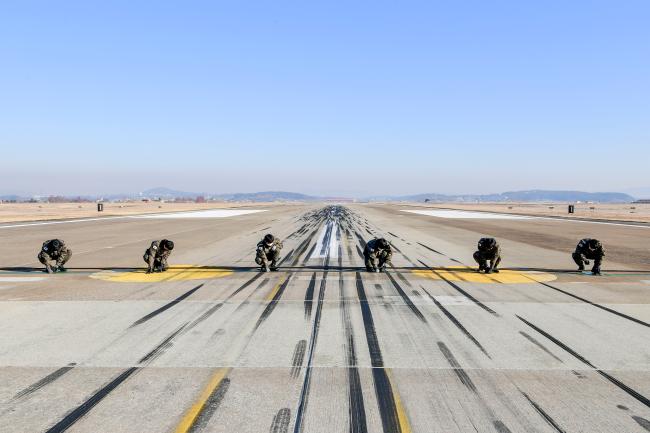 공군20전투비행단 항공기구조반 장병들이 기지 활주로에서 초과저지장비를 점검하고 있다.  사진 제공=서복남 원사