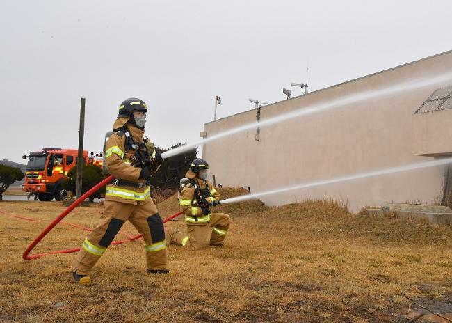 공군38전투비행전대 소방구조반 장병들이 25일 비상대기실 화재진압 훈련에서 소방호스로 불길을 잡고 있다.  사진 제공=유영임 상사
