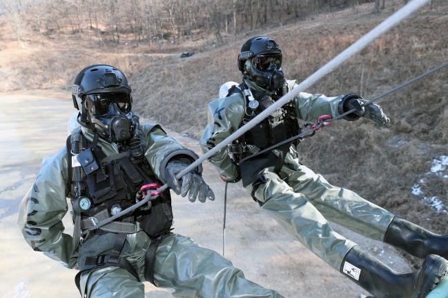 화생방테러대비 훈련  국군화생방방호사령부 예하 대화생방테러특임대 요원들이 화생방테러상황을 가정한 훈련에서 원점투입을 위해 레벨B 방호복을 입고 레펠 훈련을 하고 있다.  한재호 기자