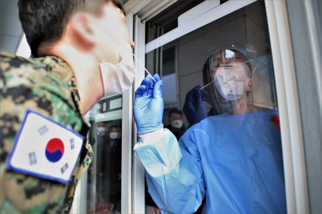 우리 군은 설 연휴를 앞두고 긴급구조·응급진료 지원태세를 빈틈없이 가동한다. 사진은 국군수도병원 선별진료소에서 군 의료진이 장병의 검체를 채취하는 모습.  의무사 제공