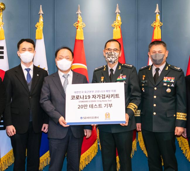 서울 용산구 육군회관에서 28일 열린 위문품 전달행사에서 남영신(왼쪽 셋째) 육군참모총장이 조영식(왼쪽 둘째) SD바이오센서 회장으로부터 코로나19 자가검사키트 20만 개를 전달받고 있다.  육군 제공