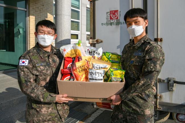 공군1전투비행단 장병들이 지난달 27일 지역경제 돕기 행사에 동참해 구매한 우리밀 상품을 받고 있다.  사진 제공=고미숙 상사