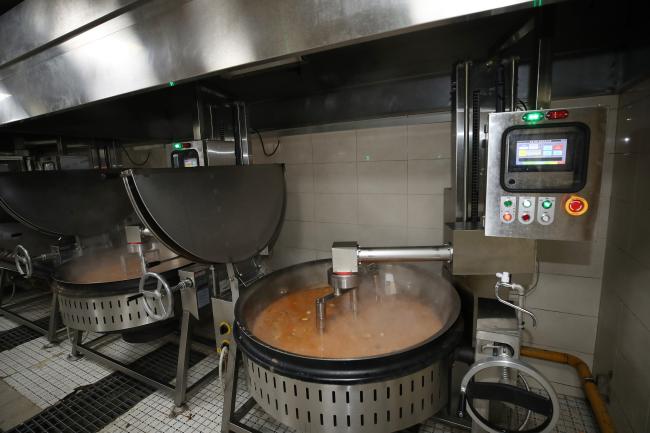 튀김 공정에 투입돼 끓는 기름에 만두를 옮겨 넣을 준비를 하고 있는 다관절 협동로봇(왼쪽)과 뜨겁게 달궈진 400인분 솥에서 된장국을 휘젓고 있는 직교로봇(오른쪽). 튀김에는 4대의 로봇이 투입되는데, 협동로봇이라는 이름처럼 다른 로봇이 컨베이어에 튀김 용기를 내려놓을 때까지 기다리기도 하고, 로봇 팔을 흔들어 기름을 털어내는 모습이 이채롭다.