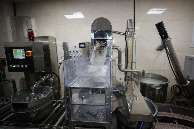 자동화 설비로 대체된 쌀 씻는 과정. 고속으로 씻겨 나오는 쌀과 적정량의 물이 자동으로 계량돼 솥에 담기는 방식이다.  