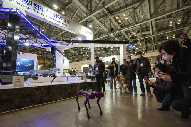 육군이 24일 부산 벡스코에서 개막한 2022 드론쇼 코리아에서 운영하는 ‘드론봇 전투체계’ 홍보부스에서 방문객들이 다족형로봇 시연을 관람하고 있다.  육군 제공