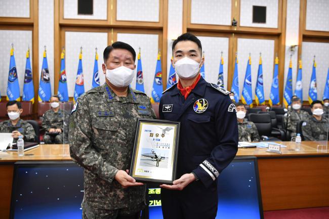 박인호(왼쪽) 공군참모총장이 ‘2021년 공군 최우수 조종사’에 선정된 11전투비행단 방주원 소령에게 대통령 표창을 수여한 뒤 기념사진을 찍고 있다.  공군 제공
