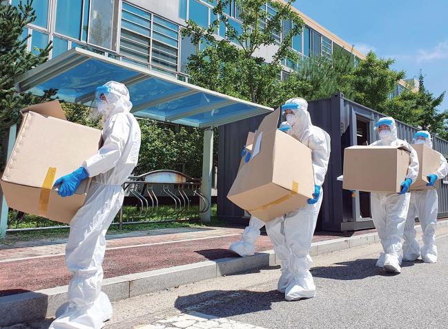 육군32보병사단 백룡 어벤져스 장병들이 충남 천안시 생활치료센터에서 환자들에게 필요한 물품을 옮기고 있다.