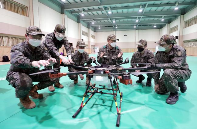 신용재(오른쪽 셋째) 중사가 동아리원들에게 드론 비행 원리를 설명하고 있다.