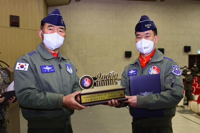 공군공중전투사령관(왼쪽)이 23일 8전투비행단 9만 시간 무사고 비행기록 달성 기념행사에서 부대 관계자에게 기념패를 수여하고 있다.  부대 제공