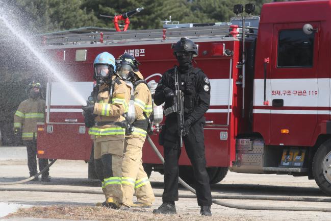 육군2공병여단이 22일 주둔지 일대에서 전개한 관·군·경 합동 대테러 종합훈련에서 출동한 소방관들이 군사경찰 특수임무대 호위를 받으며 화재를 진압하고 있다.