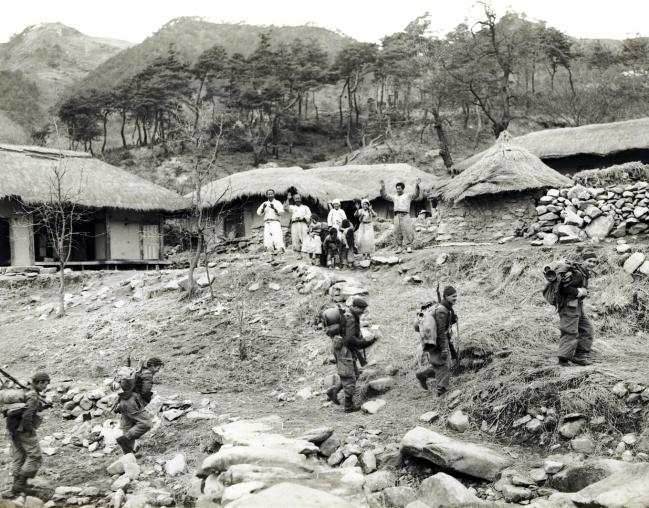 1951년 3월, 영 연방 제27여단의 예하 부대로서 후퇴하는 중공군을 향해 전진하던 패트리샤대원들이 한 한국 마을을 통과하고 있다. 
 사진=유엔평화기념관