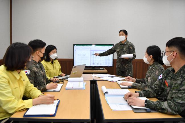 해군군수사령부 이현주 원가과장이 부서원들과 효율적인 군수품 원가조사 업무수행을 위해 시범운영 중인 로봇 사무자동화 프로그램에 대해 논의하고 있다.  
 사진 제공=김미진 중사