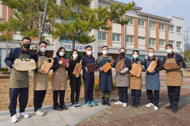 해출공방 동아리원들이 각자 제작한 도마를 들고 기념사진을 찍고 있다.사진 제공=손정민 중사 