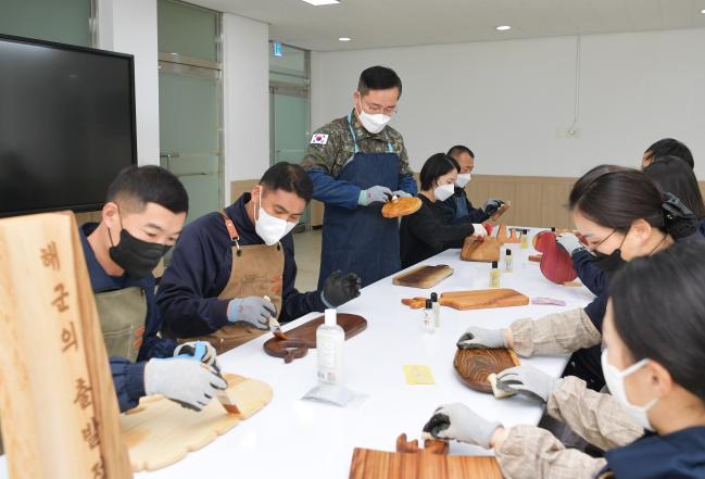  해군교육사 기초군사교육단 ‘해출공방’ 동아리원들이 각자 만든 도마에 기름을 바르는 마감 작업을 하고 있다.  

 사진 제공=손정민 중사
