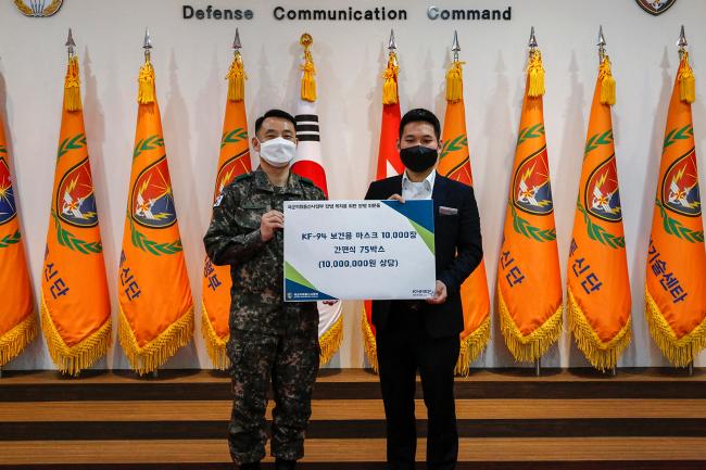 오신주 예비역 육군상병이 임강규(왼쪽) 국군지휘통신사령관에게 1000만 원 상당의 물품을 전달한 뒤 기념사진을 찍고 있다.  부대 제공