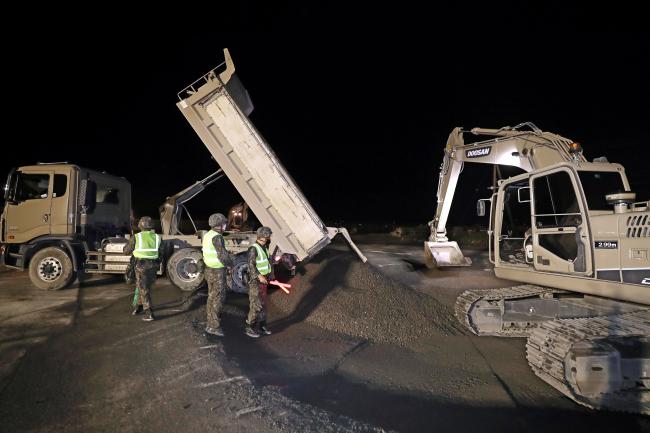 공병대대 장병들이 야간 활주로 피해복구 훈련에서 중장비를 이용해 움푹 파인 폭파구에 골재를 채우고 있다. 사진= 이경원 기자