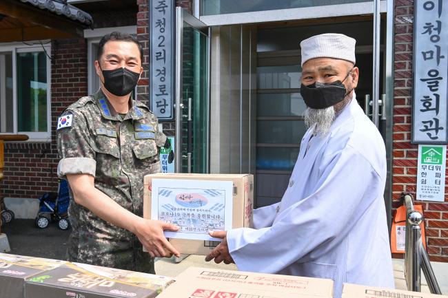 공군20전투비행단 한용호(대령·왼쪽) 감찰안전실장이 10일 충남 보령시 웅천읍 이청마을회관에서 주민 대표에게 위문품을 전달하고 있다.  사진 제공=고병재 하사