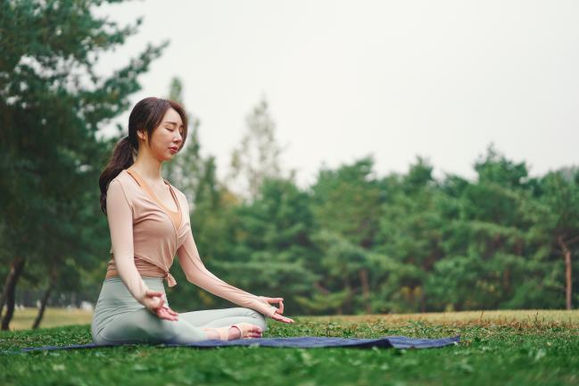 다양한 콘텐츠를 제공하는 국내외 명상 서비스 앱을 이용해 온라인으로 명상하는  Z세대가 부쩍 늘었다. 사진은 한 여성이 야외에서 명상을 하는 모습.