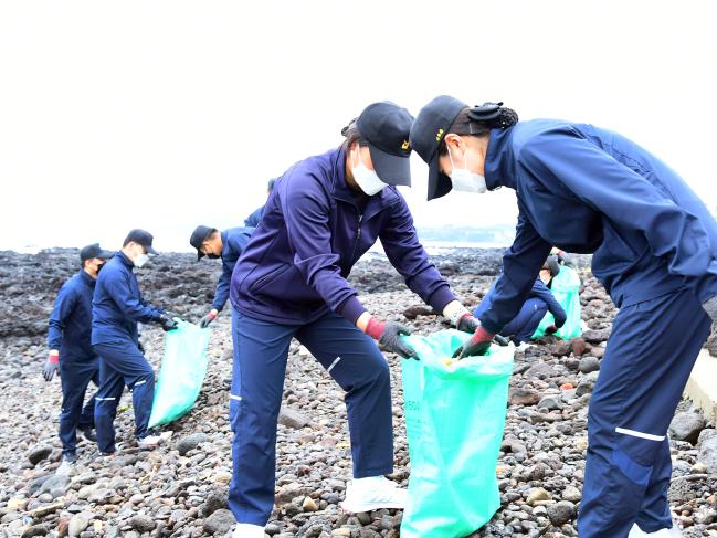 해군7기동전단 군수지원함 소양함 승조원들이 11일 제주도 서귀포시 강정마을 인근 해안가에서 쓰레기를 수거하고 있다.  사진 제공=최호진 상사(진)